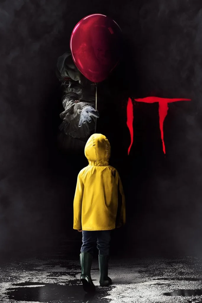 Movie poster for IT (2017), featuring a young child in a yellow raincoat standing in a dark, misty setting, facing Pennywise the Clown, who ominously extends a red balloon. The film's title appears in blood-red letters, enhancing the eerie atmosphere.