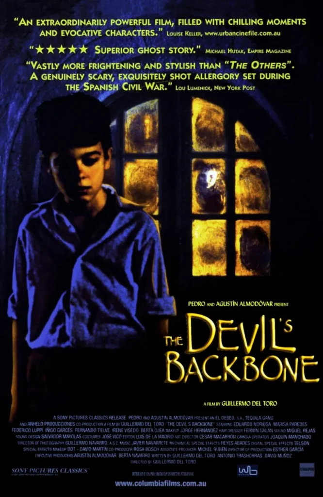 The Devil’s Backbone (2001) movie poster featuring a young boy standing in eerie blue light, his face shadowed with unease. Behind him, a window glows with warm yellow light, revealing the ghostly face of a spectral child staring out. The film’s title appears in an ominous, golden font, emphasizing the supernatural themes of Guillermo del Toro’s gothic horror set during the Spanish Civil War.