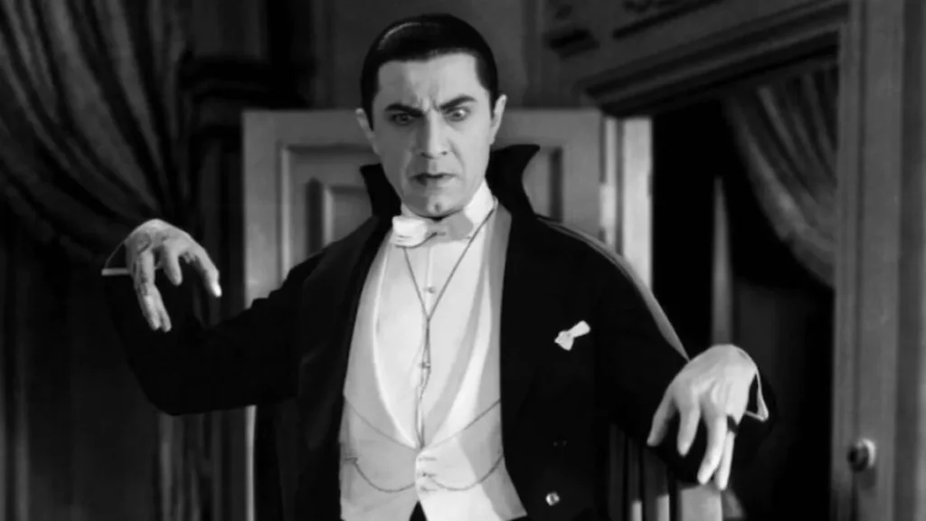 Bela Lugosi as Count Dracula in the 1931 Universal classic, wearing his iconic cape and tuxedo with a hypnotic stare and outstretched hands.