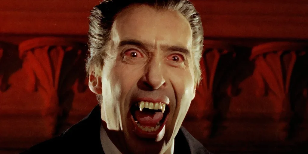 Christopher Lee as Count Dracula baring his fangs with bloodshot eyes in a Hammer Horror film.